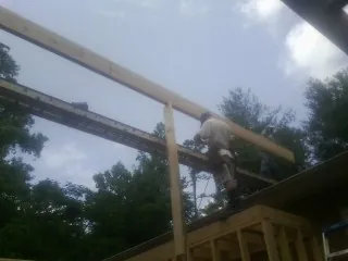 Carpenter setting a ridge beam over a new addition frame — Ice Dam Removal by Roofing Brothers in Moosup