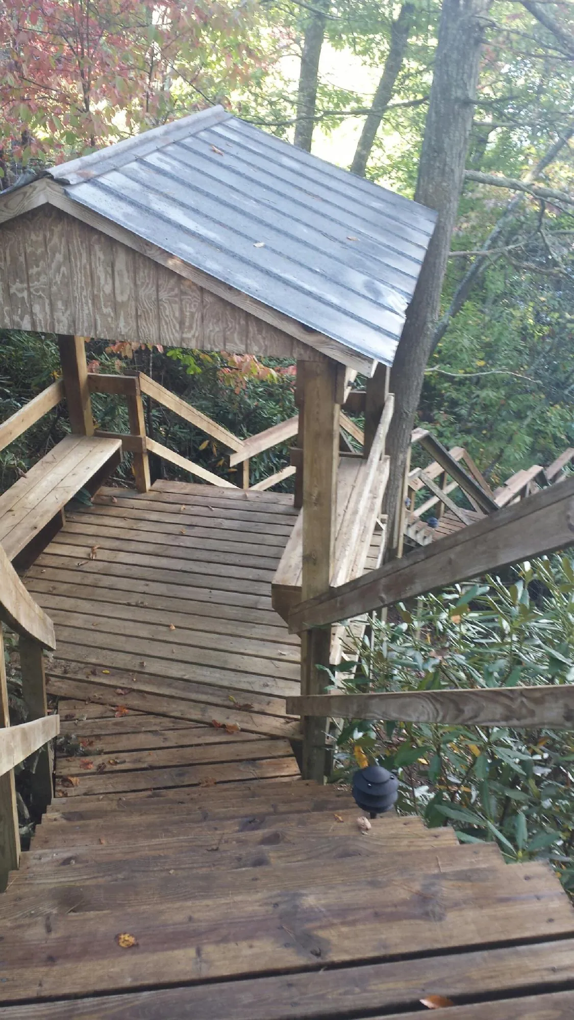 Metal roofed shelter over wooden steps on a wooded walkway — Skylight Repair & Installation work by our crew in Moosup